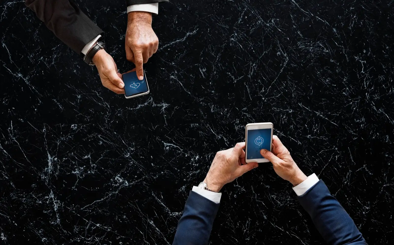Dos directivos consultando el móvil sobre una mesa
