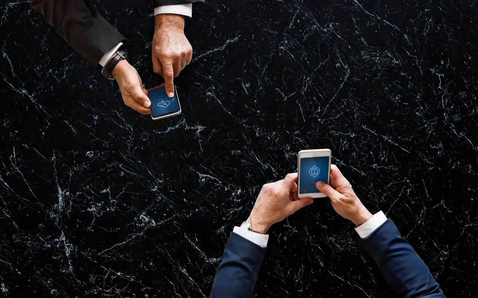 Dos directivos consultando el móvil sobre una mesa